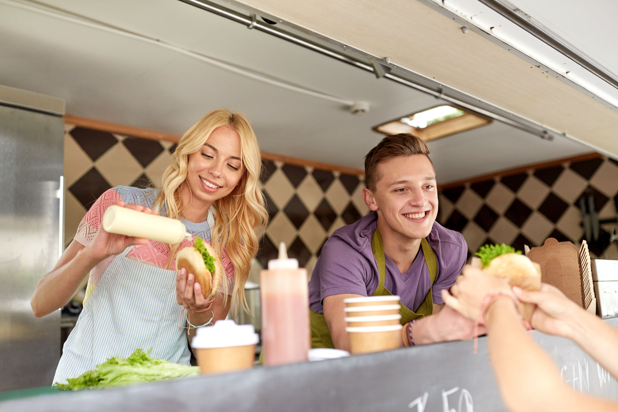Street Sale And People Concept Happy Young Sellers Serving Customers At Food Truck Happy Sellers Serving Customers At Food Truck