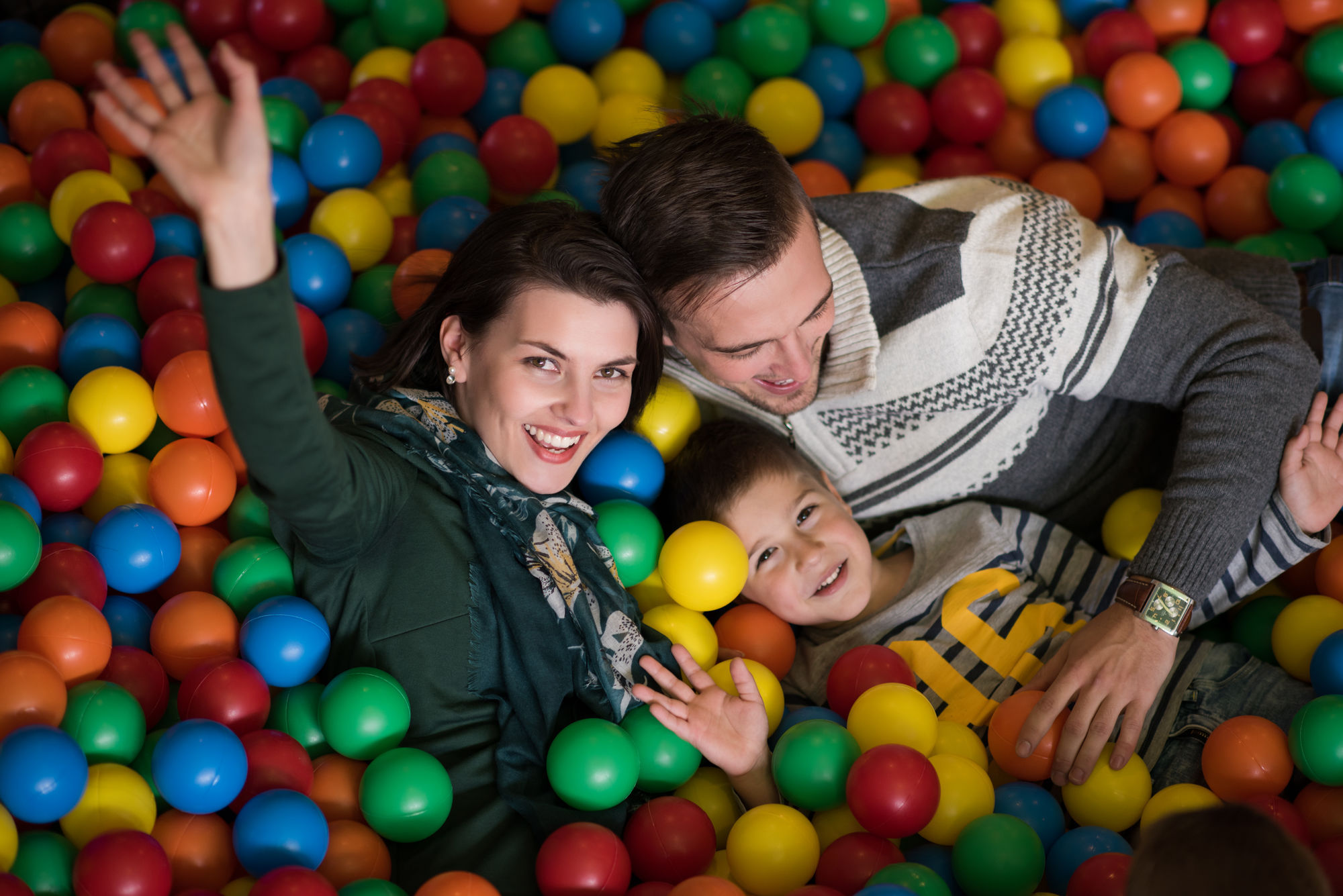 Happy Young Parents Are Playing With Their Kids At Pool With Colorful Balls In A Children S Playroom
